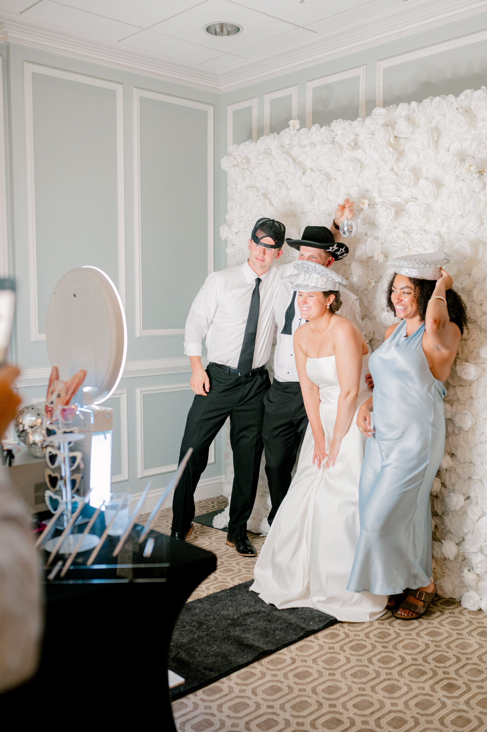 Guests using Pearl Photo Booth with White Rose Flower Wall